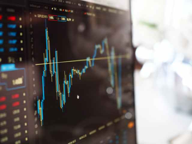 gráfico azul e amarelo no monitor do mercado de ações