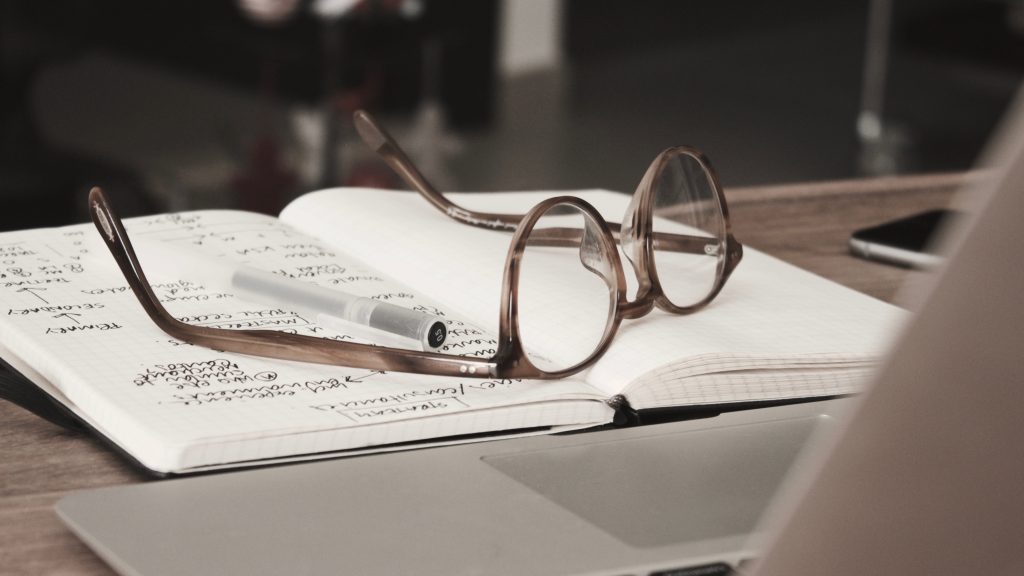 Brille mit grauem Rahmen auf der Oberseite des Notebooks