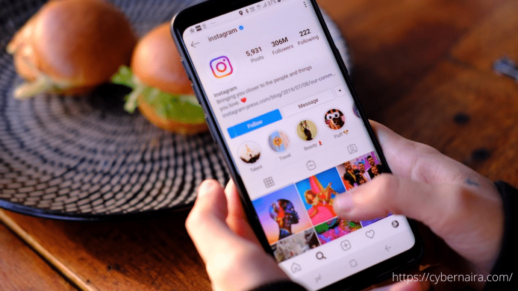 Ein Mann hält ein Smartphone mit einer darauf geöffneten Instagram-App in der Hand