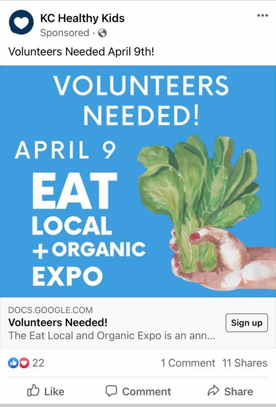 Iklan Facebook dari KC Healthy Kids yang menyertakan gambar dengan latar belakang biru, teks putih, dan gambar tangan seorang wanita yang sedang memegang selada, dan bertuliskan "Dibutuhkan sukarelawan! 9 April, Eat Local + Organic Expo" dengan ajakan bertindak untuk mendaftar