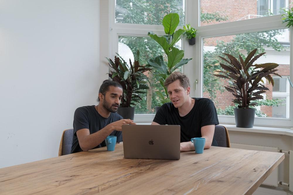 femme en t-shirt bleu à col rond utilisant un macbook argenté