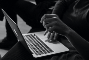 una foto en blanco y negro de una persona con una computadora portátil abierta que ilustra el comercio electrónico