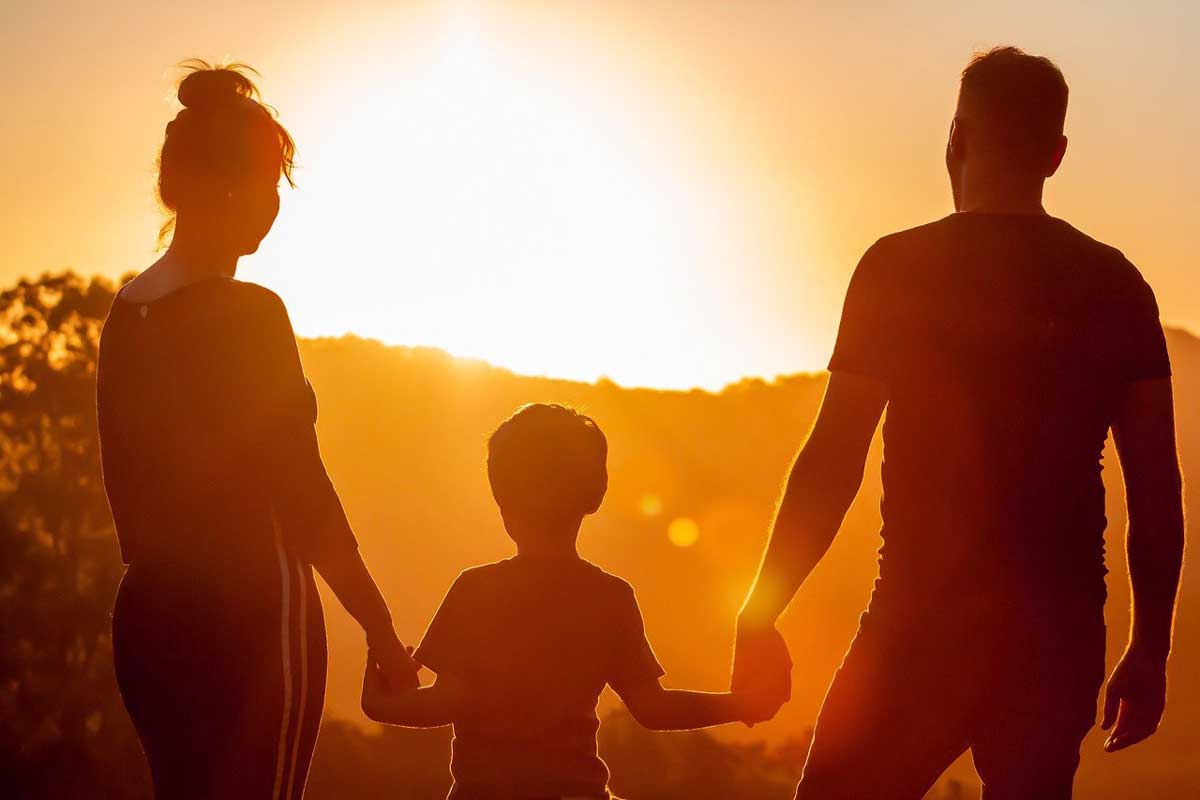 silhouette de famille devant le coucher du soleil.