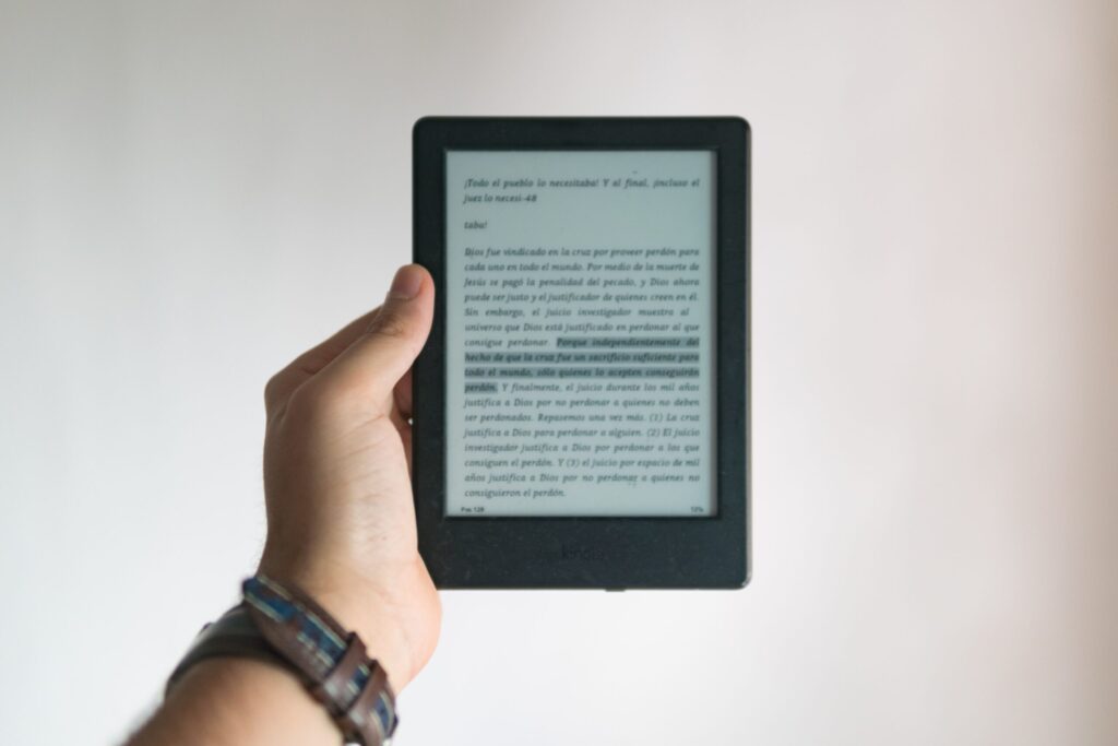 Person, die Kindle mit geöffnetem E-Book in der Hand hält