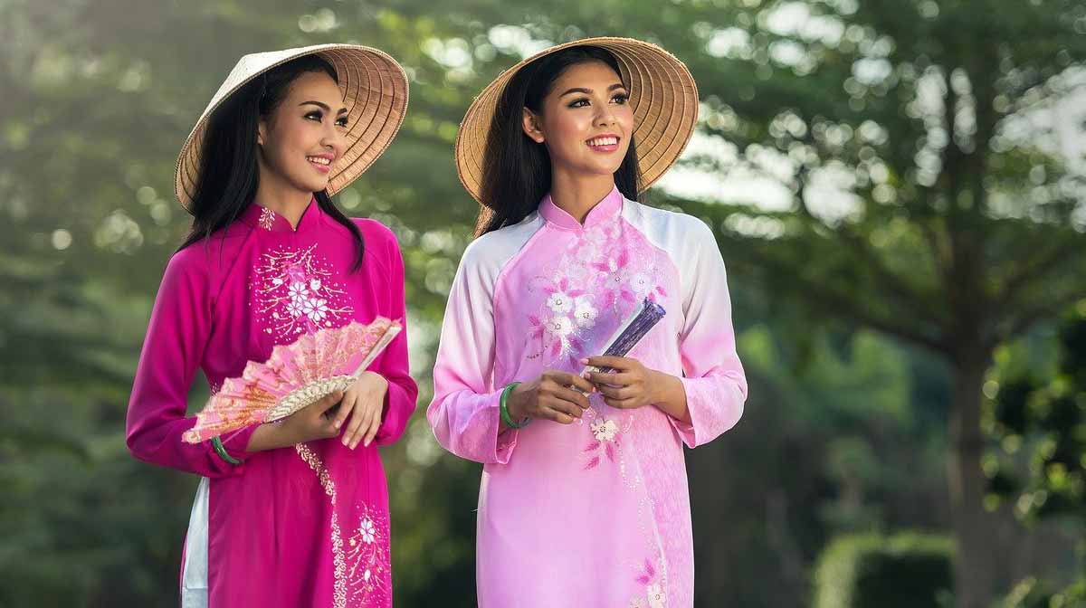 dua wanita Asia mengenakan gaun tradisional Cina dalam nuansa merah muda.