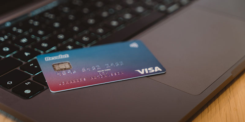 Card Visa pe un laptop gri