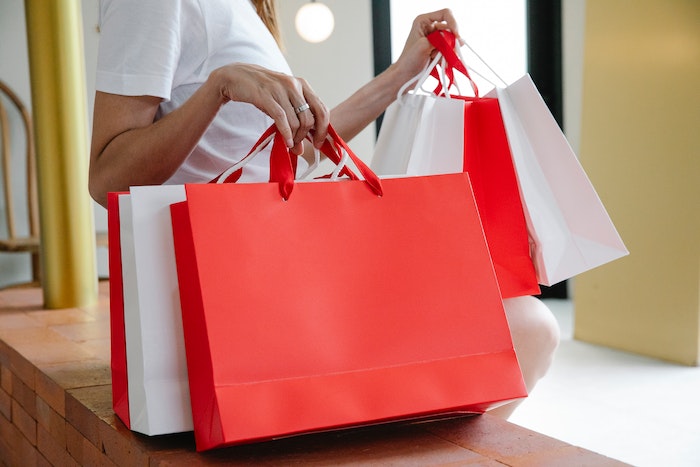 Mujer sosteniendo bolsas sin marca