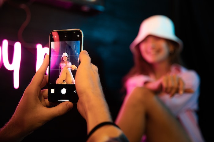 mulher de boné branco sendo fotografada