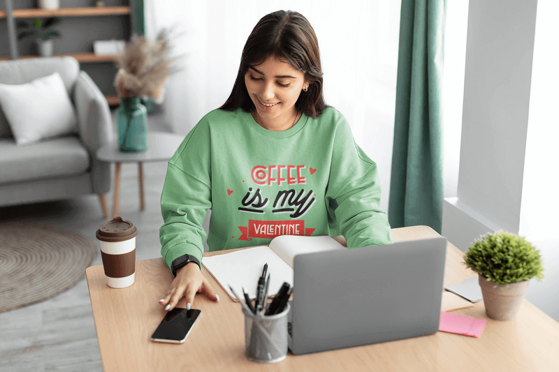 Übergroßes Sweatshirt-Modell einer Frau, die zu Hause ihren Laptop benutzt