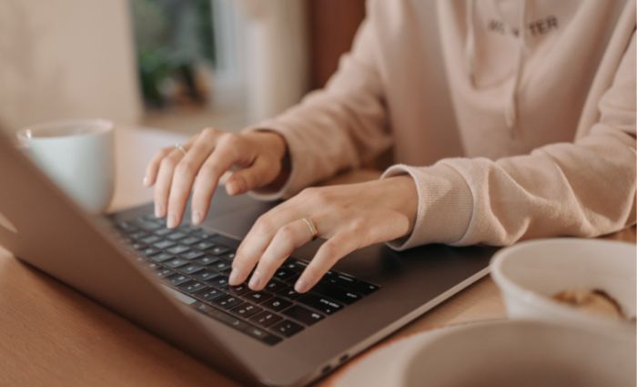 mujer escribiendo en su computadora para transcribir