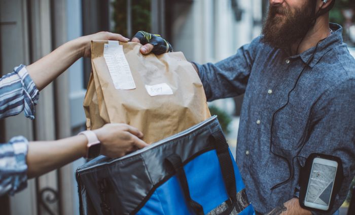 hombre entregando a mujer una entrega de comida