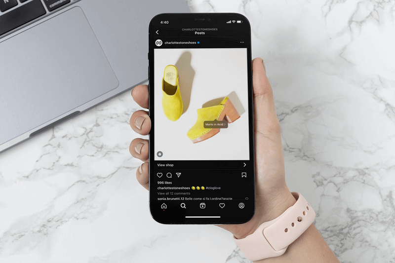 Mockup di una donna che tiene un Iphone 12 Pro Max e fa acquisti su Instagram