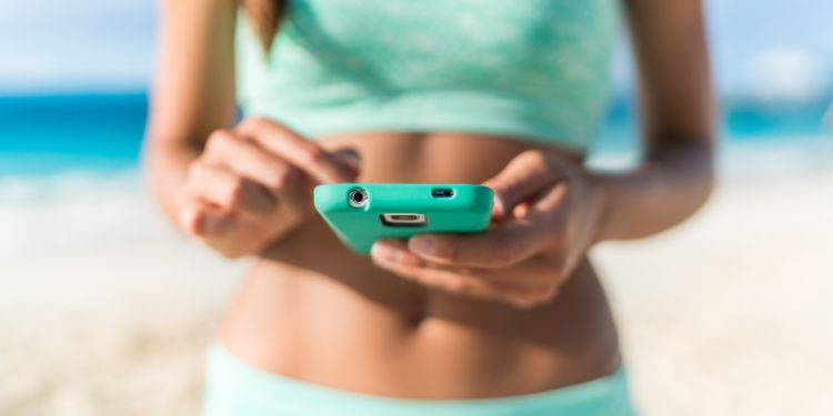 Mujer sosteniendo teléfono con aplicación de fitness