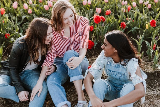 Tiga wanita tertawa dan menikmati persahabatan mereka.