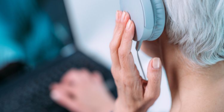 Mujer escuchando auriculares para brindar servicios de transcripción