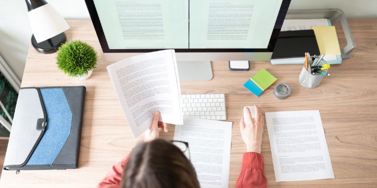 Femme traduisant des documents sur son bureau