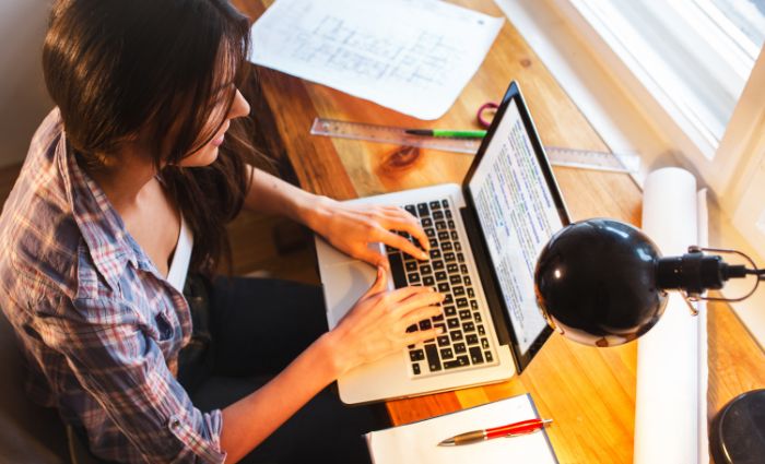 Frau tippt als virtuelle Assistentin am Computer