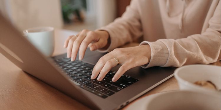 mujer escribiendo en una computadora como escritora independiente