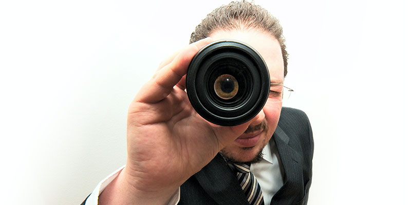 Un hombre de traje mirando a través de un binocular