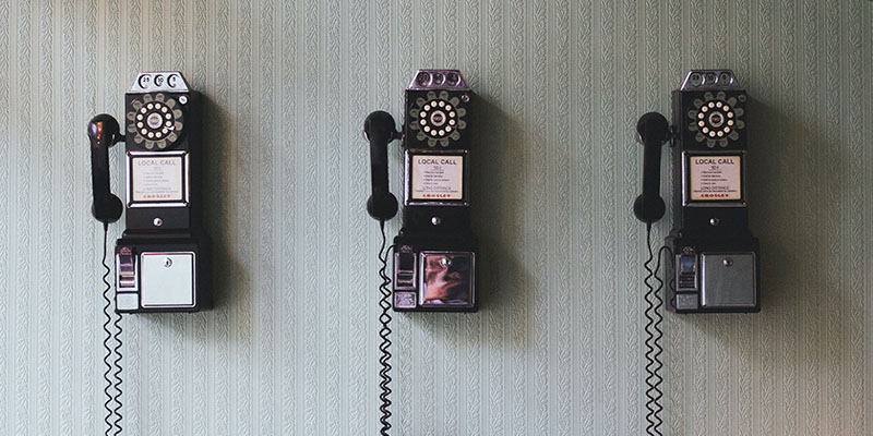 Tres teléfonos antiguos en una pared.