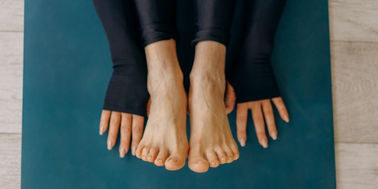 mani e piedi su una stuoia di yoga