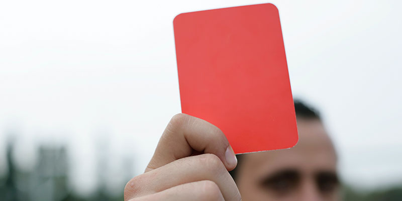 Ein Schiedsrichter hält eine rote Karte