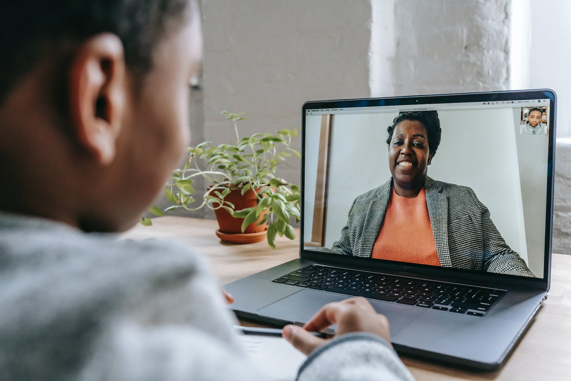 pupil studying at home with laptop with the help of online tutor