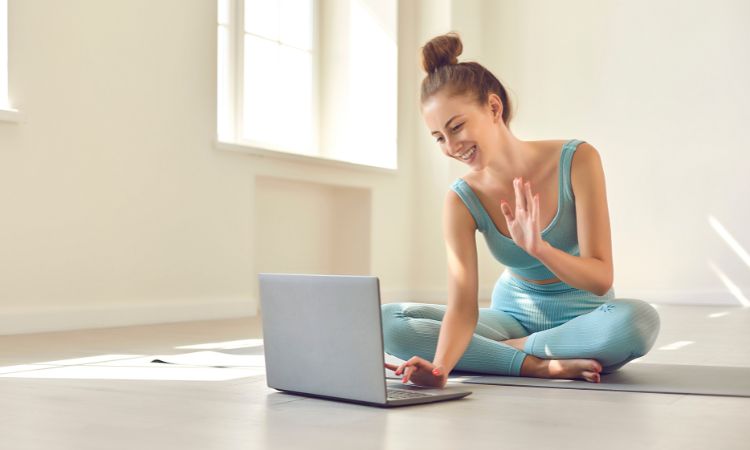 antrenor de fitness online făcându-și cu mâna la computer