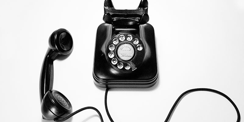 Um telefone vintage preto em uma mesa branca