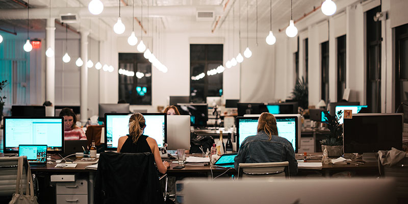 Karyawan bekerja di meja mereka di kantor ruang terbuka yang besar