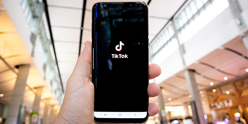 Eine Hand, die ein Telefon mit einer TikTok-App zeigt