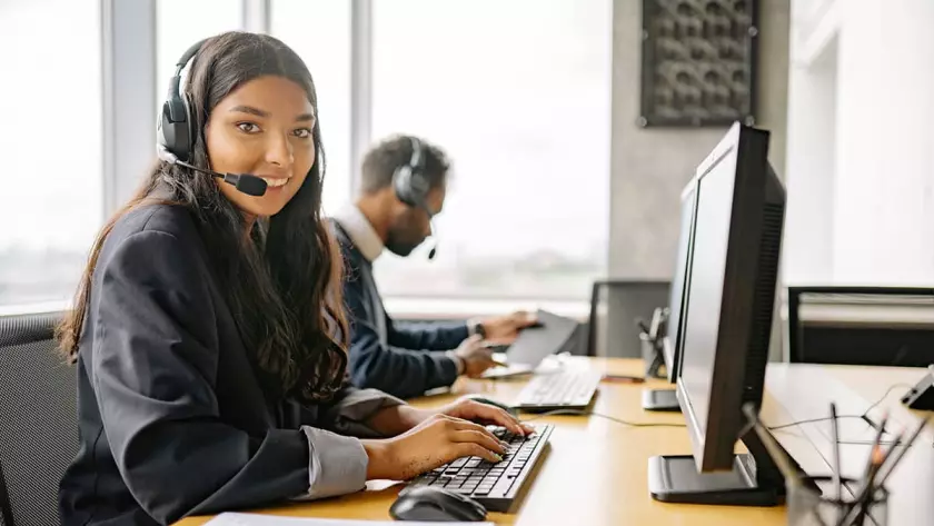 Eine Frau und ein Mann arbeiten an einem Computer in einem Callcenter.