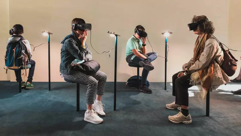 Eine Gruppe von Menschen sitzt mit VR-Headsets in einem Raum.