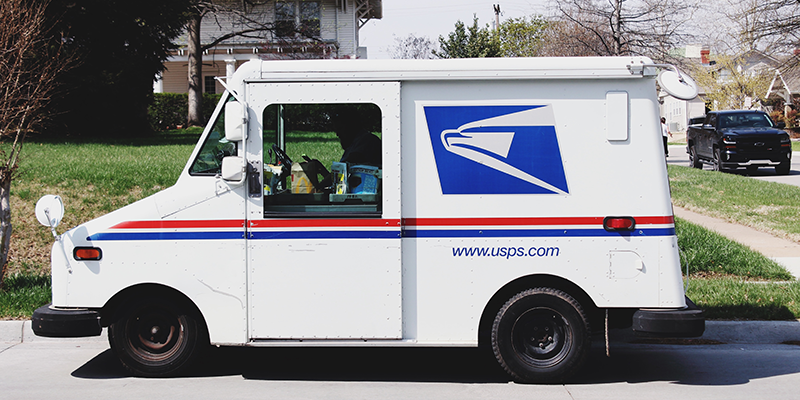 Furgonetă de livrare USPS într-un cartier suburban