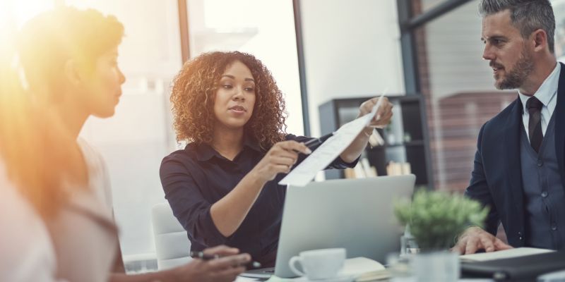 pessoas em um escritório olhando um relatório