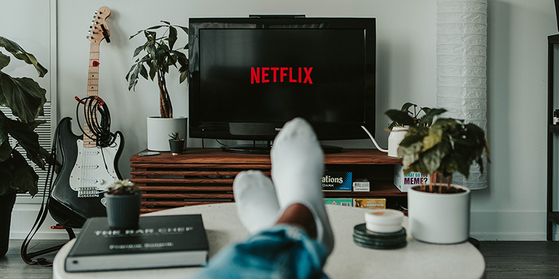 Um homem assistindo Netflix em sua sala de estar