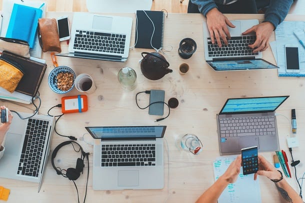 Imagen de personas alrededor de una mesa trabajando frente a sus computadoras.