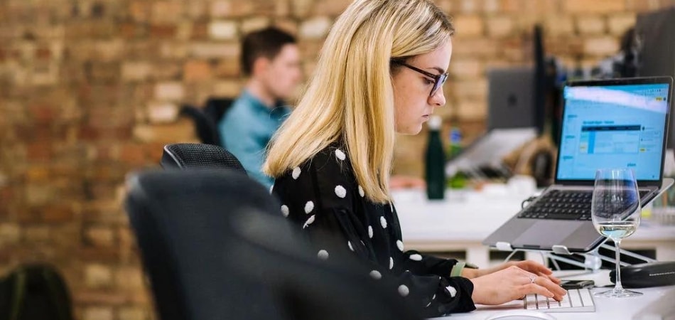 Una empleada de Gripped estaba sentada trabajando en una computadora en un escritorio.